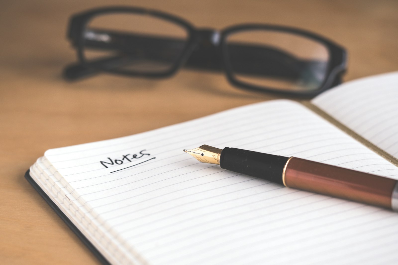 Notitieboek met pen op een houten bureau